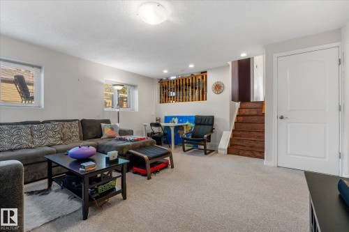 Carpeted flooring, recessed lighting, white interior walls, wood-finish staircase, and white paneled door - 4103 44 Avenue, Stony Plain, AB 