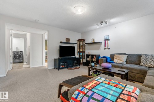Carpeted living area with white walls and overhead flush-mount lighting - 4103 44 Avenue, Stony Plain, AB 