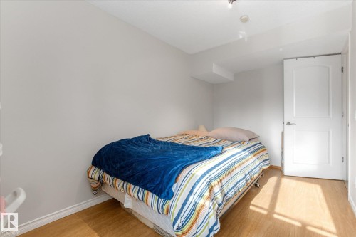 Wood-finish flooring with white baseboards, a white interior door, and light-toned walls - 4103 44 Avenue, Stony Plain, AB 