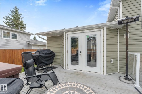 Wood-finish deck with a patio cover, double glass panel doors, and neutral-toned siding - 4103 44 Avenue, Stony Plain, AB 
