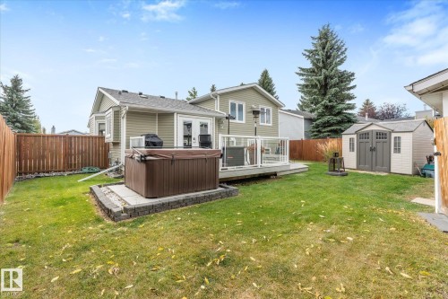 Expansive lawn with a wooden deck, hot tub, and storage shed - 4103 44 Avenue, Stony Plain, AB 