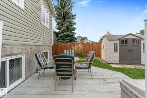 Expansive wooden deck with a privacy fence, storage shed, and a manicured lawn - 4103 44 Avenue, Stony Plain, AB 