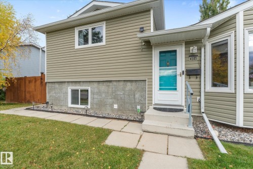 Light-toned siding exterior with a contrasting teal entry door - 4103 44 Avenue, Stony Plain, AB 