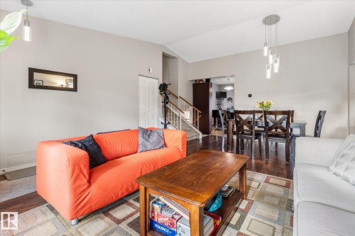 Open-concept living and dining areas with dark wood-finish flooring - 4103 44 Avenue, Stony Plain, AB 