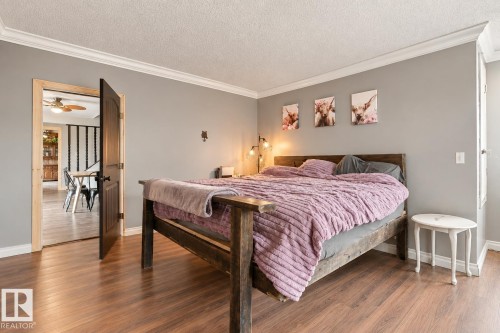 Wood-finish flooring, crown molding, gray painted walls, and a dark wood door frame - 62202 Rr 444, Rural Bonnyville M.D., AB 