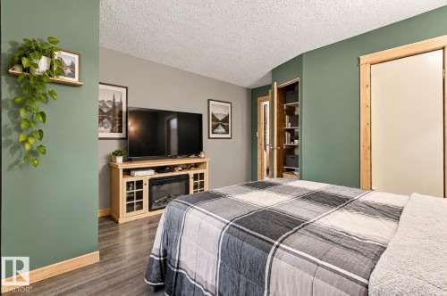 Wood-finish flooring, built-in media console with integrated fireplace, and wood trim details - 62202 Rr 444, Rural Bonnyville M.D., AB 