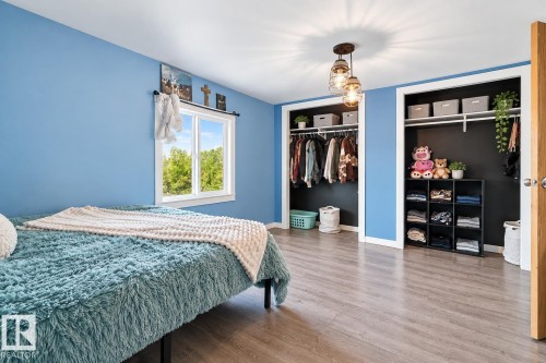 Wood-finish flooring, dual built-in closets with shelving, a single window, and a decorative ceiling light fixture - 62202 Rr 444, Rural Bonnyville M.D., AB 