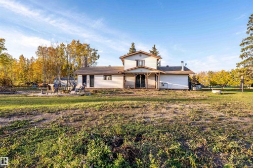 Expansive property featuring a two-story residence with a covered patio, a fire pit area, and mature trees surrounding the perimeter - 62202 Rr 444, Rural Bonnyville M.D., AB 