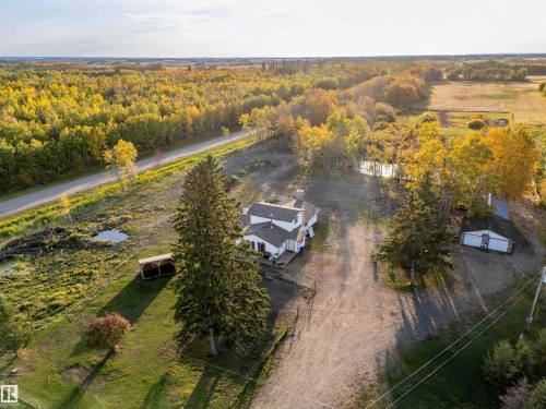 Expansive property featuring a residence, detached outbuilding, mature trees, and a pond - 62202 Rr 444, Rural Bonnyville M.D., AB 