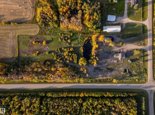 Aerial property overview featuring an established structure, outbuildings, and a water feature - 62202 Rr 444, Rural Bonnyville M.D., AB 
