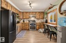 Kitchen featuring wood-finish cabinetry, stainless steel appliances, and wood-finish flooring - 62202 Rr 444, Rural Bonnyville M.D., AB 