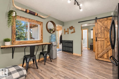 Wood-finish flooring throughout, with a rustic wood-framed window and live-edge wood shelf - 62202 Rr 444, Rural Bonnyville M.D., AB 