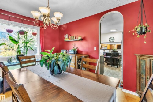 Hardwood-finish flooring, a decorative chandelier, and an arched doorway - 76 Gariepy Crescent Nw, Edmonton, AB 