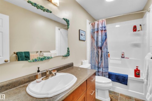 Wood-finish vanity with an integrated sink and bronze-finish faucet - 76 Gariepy Crescent Nw, Edmonton, AB 