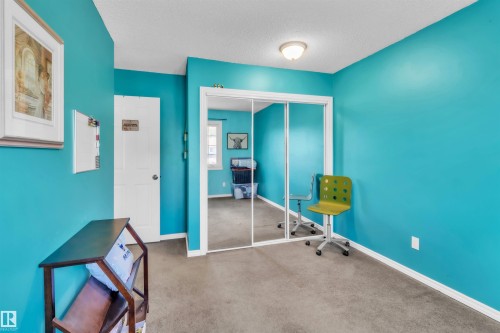 Wall-to-wall carpeting with mirrored closet doors and a ceiling-mounted light fixture - 76 Gariepy Crescent Nw, Edmonton, AB 