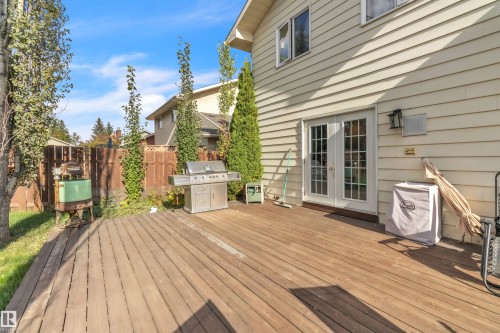 Expansive wood deck with French patio doors and exterior wall lantern - 76 Gariepy Crescent Nw, Edmonton, AB 