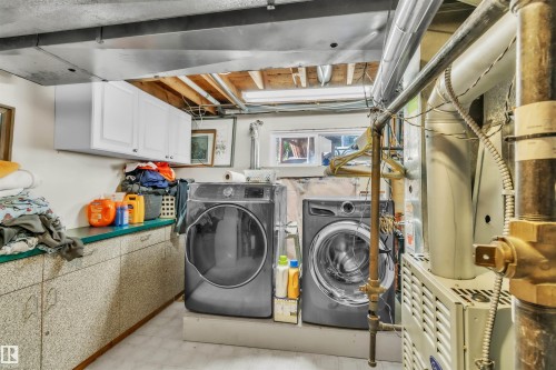Laundry area with white upper cabinetry, a utility countertop, and a window - 76 Gariepy Crescent Nw, Edmonton, AB 
