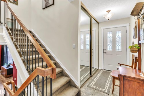 Staircase featuring wood handrails and wrought iron spindles - 76 Gariepy Crescent Nw, Edmonton, AB 