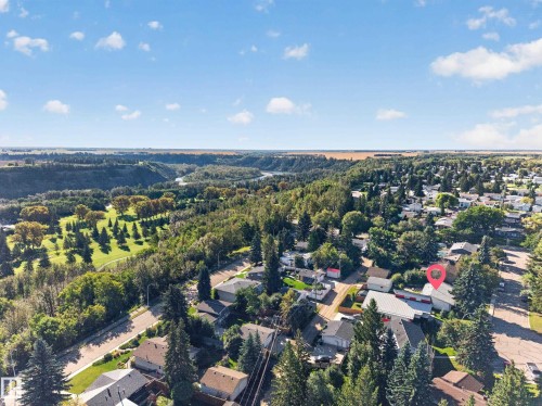 Aerial perspective showcasing a residential area with varied rooflines and extensive tree cover - 23 Clearwater, Devon, AB 