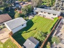 Expansive backyard with a manicured lawn, established landscaping, and a detached garage - 23 Clearwater, Devon, AB 
