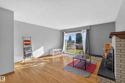 Hardwood flooring, sliding glass door, brick fireplace with hearth, and painted walls - 