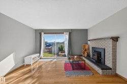 Hardwood flooring, brick-faced fireplace with hearth, and sliding glass door - 