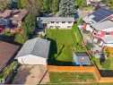 Expansive backyard featuring a manicured lawn, mature trees, and a detached two-car garage - 23 Clearwater, Devon, AB 