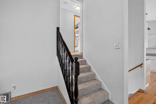 Carpeted staircase with dark wood-finish balusters and handrail - 23 Clearwater, Devon, AB 