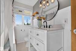 White vanity with polished chrome hardware, black faucet, and light-toned countertop - 