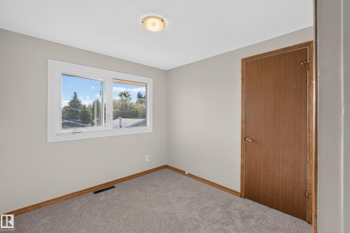 Neutral wall paint, carpeted flooring, wood-finish trim, and a flush mount ceiling light - 23 Clearwater, Devon, AB 