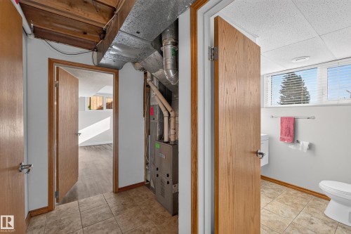 Tile flooring, exposed ceiling beams, and a utility area featuring a furnace - 23 Clearwater, Devon, AB 