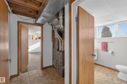 Tile flooring, exposed ceiling beams, and a utility area featuring a furnace - 