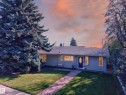Single-story residence featuring light blue siding and a dark gray shingle roof - 23 Clearwater, Devon, AB 