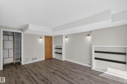 Wood-finish flooring, recessed wall shelving, built-in closet organization, contemporary wall sconces, and a solid wood door - 