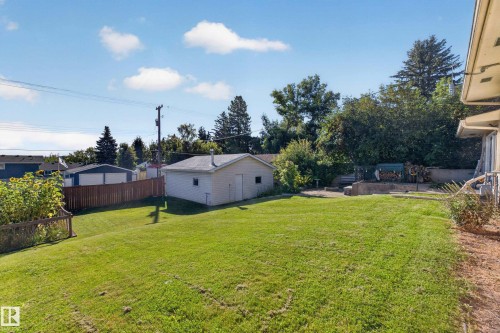 Expansive backyard with a manicured lawn, dedicated detached garage, and wood privacy fencing - 23 Clearwater, Devon, AB 