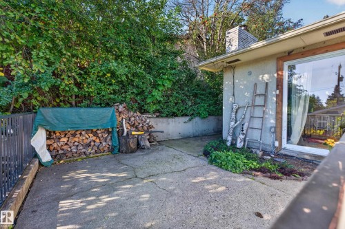 Concrete patio with retaining wall, stucco exterior, and sliding glass door - 23 Clearwater, Devon, AB 