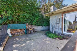 Concrete patio with retaining wall, stucco exterior, and sliding glass door - 