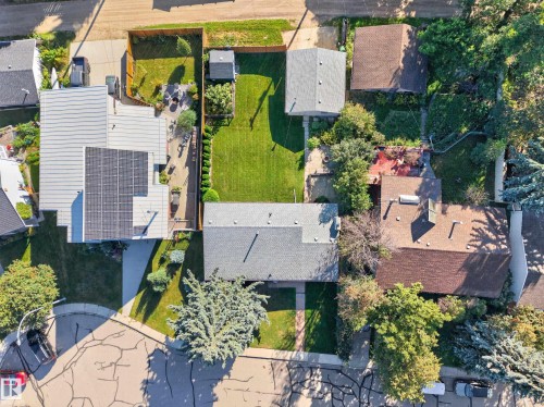 Expansive rear yard featuring a manicured lawn, established landscaping, and a patio area - 23 Clearwater, Devon, AB 