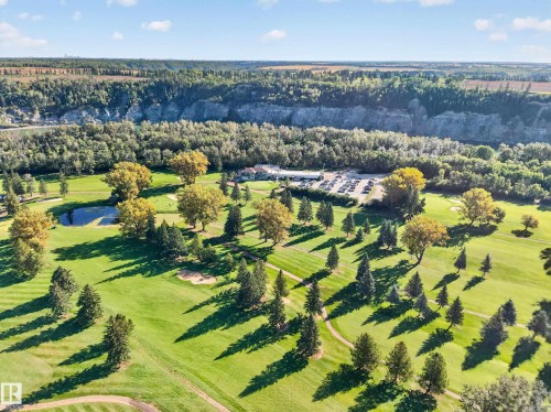 Expansive golf course with manicured greens, sand traps, mature trees, and a visible water feature - 23 Clearwater, Devon, AB 
