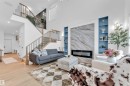 Two-story living area with high ceilings, wood-finish flooring, and a contemporary linear fireplace - 2 Tenuto Link, Spruce Grove, AB 