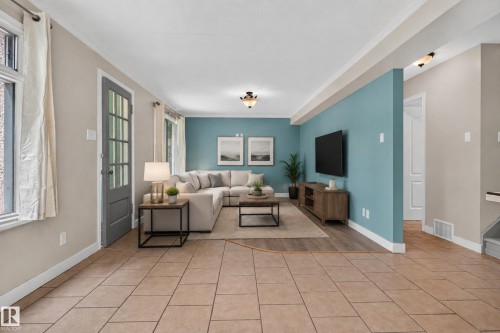 Expansive common area featuring tiled flooring, wood-finish flooring, a French-style door with multiple glass panes, and a decorative wall - 11549 88 Street Nw, Edmonton, AB 