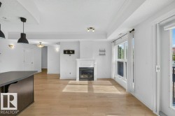 Recessed lighting, wood-finish flooring, white fireplace, and a large sliding glass door - 
