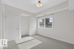 Recessed lighting, light-colored carpeting, white wall paint, and a window with white trim - 
