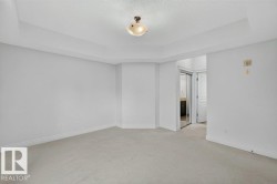 Recessed ceiling detail, neutral wall paint, carpet flooring, flush mount lighting, and a mirrored closet door - 