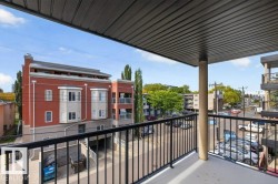 Private balcony with a metal railing, concrete flooring, and an overhead soffit - 