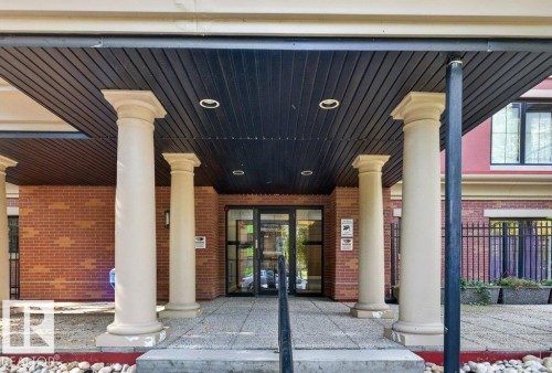 Brick exterior featuring four columns, a covered entry with recessed lighting, and a glass double door entrance - #306 10232 115 St Nw, Edmonton, AB 