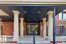 Brick exterior featuring four columns, a covered entry with recessed lighting, and a glass double door entrance - 