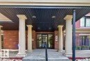 Brick exterior featuring four columns, a covered entry with recessed lighting, and a glass double door entrance - #306 10232 115 St Nw, Edmonton, AB 
