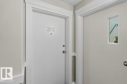 Entryway featuring a white door with numeric designation, polished hardware, and a framed window - 
