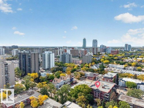 City skyline with a mix of residential and commercial buildings, surrounded by a canopy of trees - #306 10232 115 St Nw, Edmonton, AB 